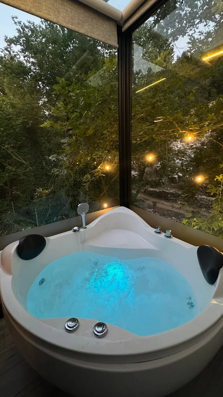 Breeze Bungalow jacuzzi at night with ambient lighting and forest views